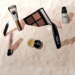 A collection of makeup products displayed stylishly on a textured surface, perfect for beauty themes.