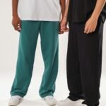 Two individuals showcasing casual fashion featuring loose pants and relaxed attire.